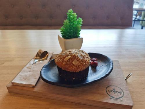a chocolate cupcake on a plate on a wooden table at Interpark Hotel & Residence, Eastern Seaboard Rayong in Ban Phan Sadet Nok
