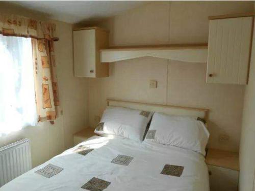 Säng eller sängar i ett rum på Cosy caravans Sandhills 175 butlins Skegness resort