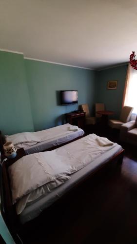 una camera da letto con due letti e una stanza con un divano di Villa Rosse a Danzica