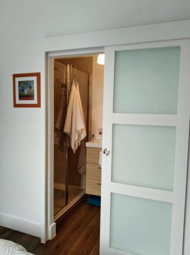 une porte menant à une salle de bains pourvue d'une douche. dans l'établissement grande terrasse arborée, à Brest