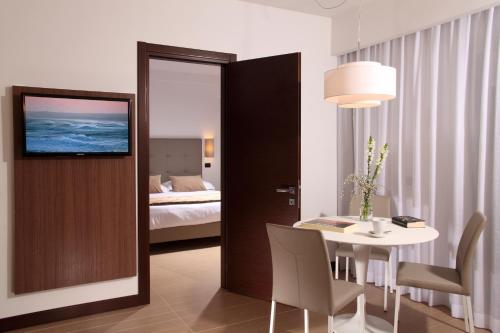 ローマにあるレジデンス ホテル パリオーリのテーブル付きの部屋、ベッド付きのベッドルーム1室が備わります。
