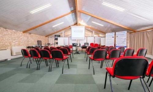 a conference room with red chairs in a room at Hotel Restaurant La Dame du Lac in Monflanquin