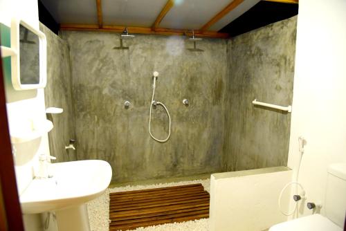 a bathroom with a shower and a sink at Prime Surfers Bungalow in Arugam Bay