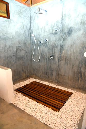 a shower with a metal grate in a bathroom at Prime Surfers Bungalow in Arugam Bay