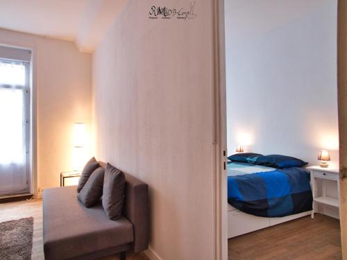 - une chambre avec un lit et une chaise dans l'établissement Appartement hypercentre au 1er, ZOO - 24h du Mans, à La Flèche