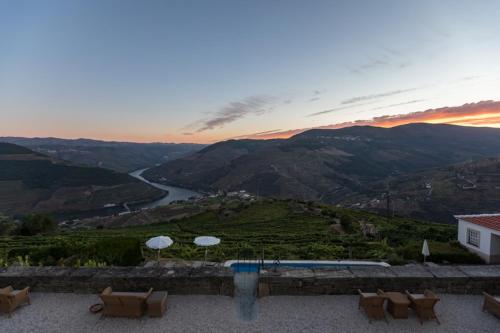 a patio with a view of a river and mountains at Casa De Casal De Loivos in Pinhão