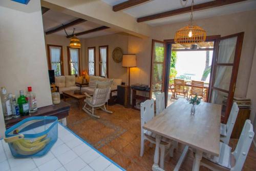 a dining room with a table and chairs and a living room at Natali's Villa by the sea in Kato Gatzea