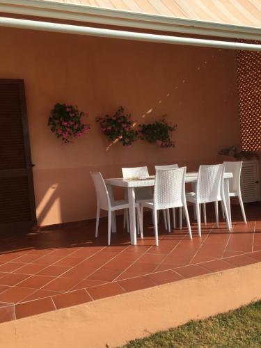 a white table and chairs on a patio at La casa sotto la torre in Chia