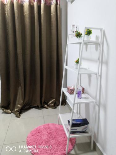 a white ladder shelf in a room with a pink rug at Abah 2 Room Homestay in Pasir Gudang