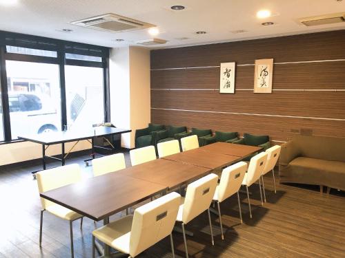 a conference room with a wooden table and chairs at Business Hotel Sunpu in Shizuoka