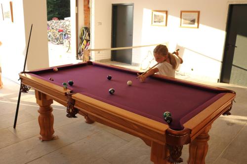 a little girl playing with a pool table at The Lodge in Rogaška Slatina