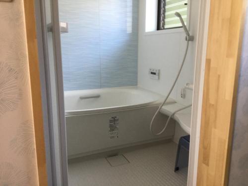 a bathroom with a bath tub and a sink at 民泊大森 in Iyo
