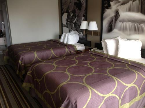 a hotel room with two beds next to each other at Super 8 by Wyndham Longview/North in Longview