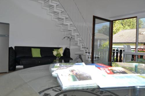 een woonkamer met een bank en een glazen tafel bij Ferienwohnung Stimmer in Grainau