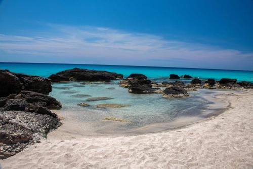 a sandy beach with rocks and the ocean at Villa Kore Elafonissi in Ãyios FÃ³tios