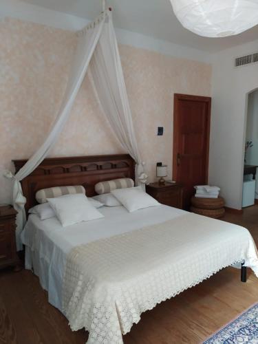 a bedroom with a white bed with a canopy at Bed & Breakfast Lujocanda in Casarza Ligure