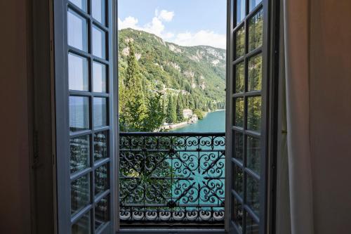 an open window with a view of a river and mountains at Hotel Villa Cipressi, by R Collection Hotels in Varenna