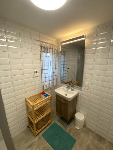 ディードリッヒシュハーゲンにあるOstseebungalow HaningHuusのバスルーム(洗面台、トイレ、鏡付)