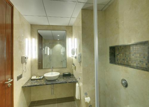 a bathroom with a sink and a mirror at Lemon Tree Premier, Dwarka in Dwarka