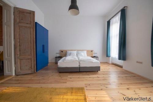 a bedroom with a bed and a blue door at Várkerület 6 Apartman in Sárvár