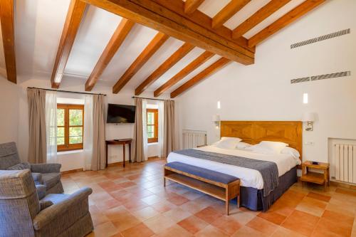 a bedroom with a bed and a couch and a chair at Son Grua Agroturismo - Adults only in Pollença