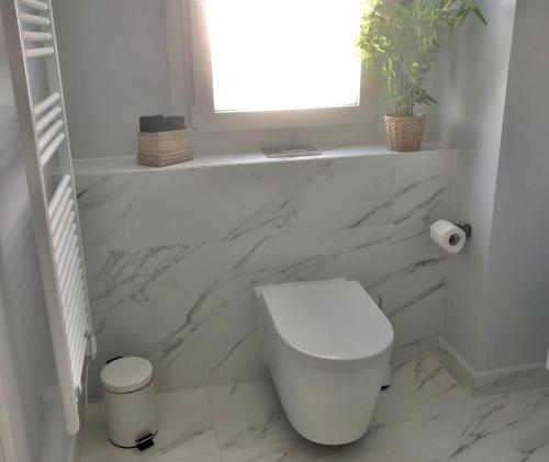 a white bathroom with a toilet and a window at Angel Suites in Nicosia