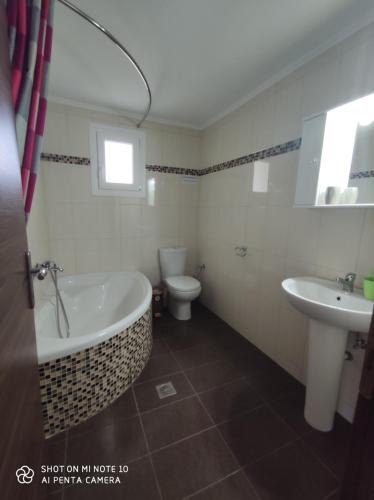 a bathroom with a tub and a toilet and a sink at Villa Anastasia in Keramoti