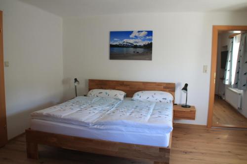 ein Bett in einem Schlafzimmer mit einem Bild an der Wand in der Unterkunft Ferienwohnungen Hornmansreithof in Sankt Koloman