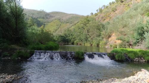 a waterfall in the middle of a river at Casa do Rio in Coimbra
