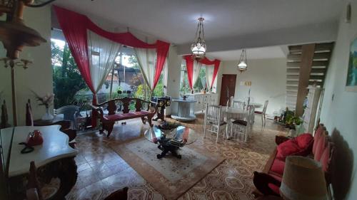 uma sala de estar com mobiliário e uma sala de jantar em Pousada Charitas Inn em Niterói