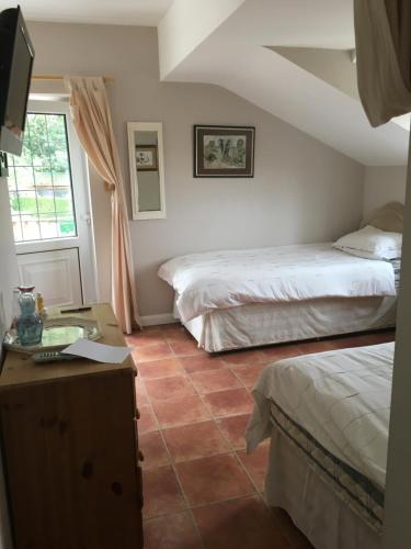 Hooe的住宿－Rosemary Cottage，酒店客房设有两张床和电视。