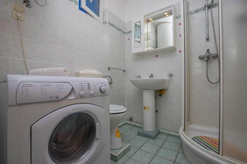 y baño con lavadora y aseo. en Apartman Zlatica, en Dramalj