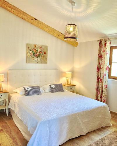 a bedroom with a large white bed with two pillows at Domaine de La Brave in Pernes-les-Fontaines