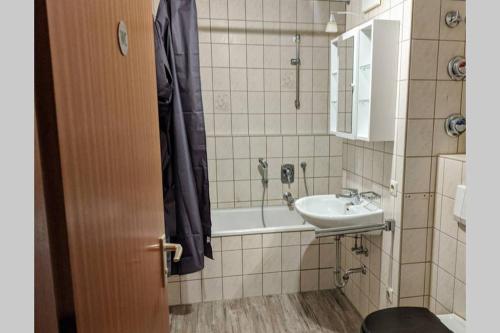 a bathroom with a sink and a bath tub at ideale Messe/Airport Wohnung 15min Fahrtweg in Kirchheim unter Teck