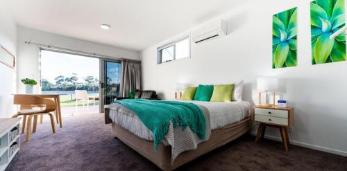 a bedroom with a bed and a desk and a window at Ulverstone River Edge HolidayApartments in Ulverstone