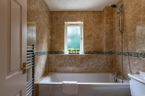 Chandlers House في بيتيربورو: حمام مع حوض ومغسلة ونافذة