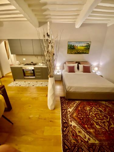 a bedroom with a large bed and a kitchen at Sisters’home in Cortona