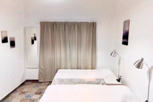 een witte kamer met 2 bedden en een raam bij Efigenia playa/mar 2 in Valle Gran Rey