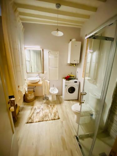 a bathroom with a toilet sink and a washing machine at Sisters’home in Cortona