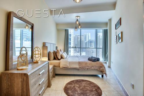 a bedroom with a bed and a large window at The Waves by DAMAC, Dubai Marina in Dubai