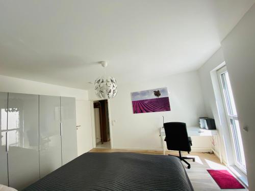 a bedroom with a bed and a desk and a chair at Moderne Wohnung im Rhein-Main-Gebiet in Idstein