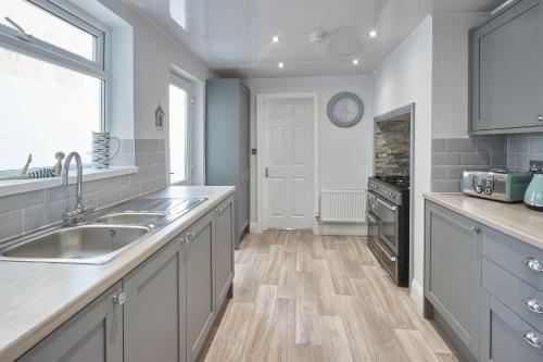 a kitchen with a sink and a stove at Host & Stay - Riftswood at Ruby in Saltburn-by-the-Sea