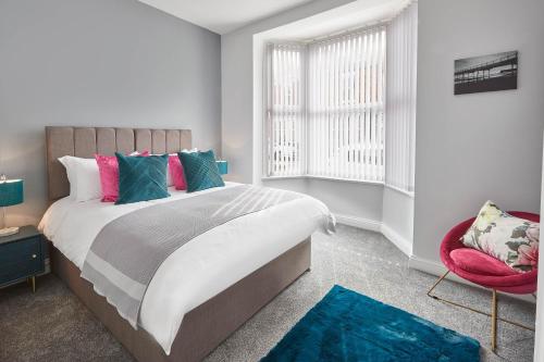 1 dormitorio con 1 cama grande y 1 silla roja en Host & Stay - Riftswood at Ruby en Saltburn-by-the-Sea
