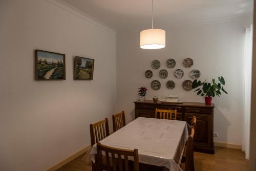 uma sala de jantar com uma mesa e pratos na parede em Quinta da Cidade em Ponta Delgada