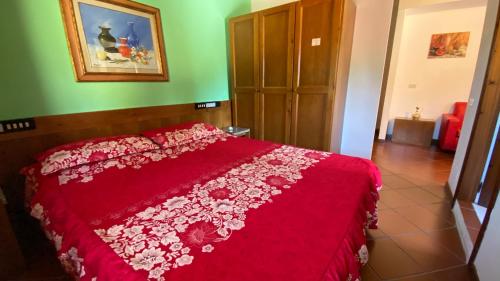 a bedroom with a red bed with a red comforter at Motorrad-Hotel Toskana con piscina e giardino nel Chianti in Montespertoli