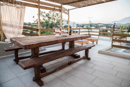 a wooden table and benches on a patio at Chalkidιό in Pitsidia
