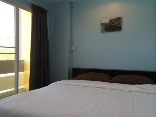 a bedroom with a bed and a window at U Dee Room and Coffee in Kanchanaburi