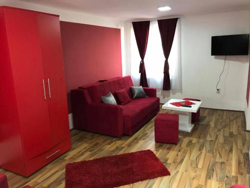 ein Wohnzimmer mit einem roten Sofa und einem Tisch in der Unterkunft Studio Ivana 1 in Sokobanja