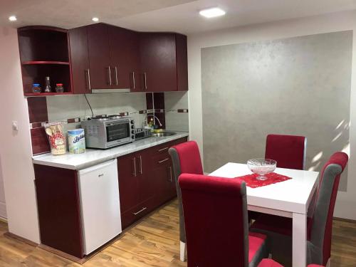 una cucina con tavolo e una cucina con forno a microonde di Studio Ivana 1 a Soko Banja