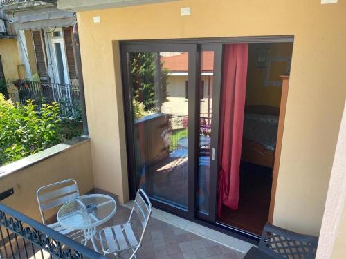 a balcony with a glass door with a table and chairs at The Queen Tower in Desenzano del Garda